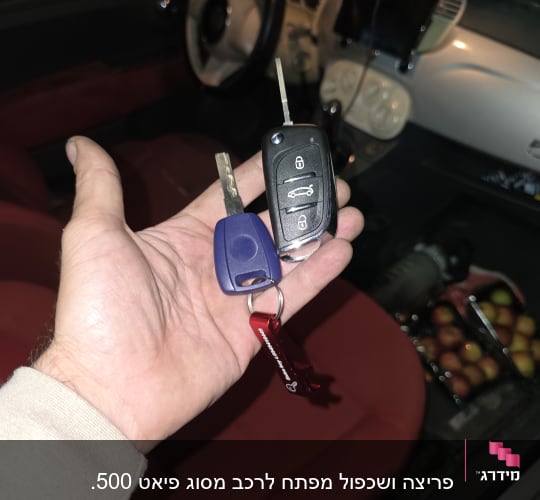מפתחות רכב ביד בתוך מכונית עם מושבים אדומים
